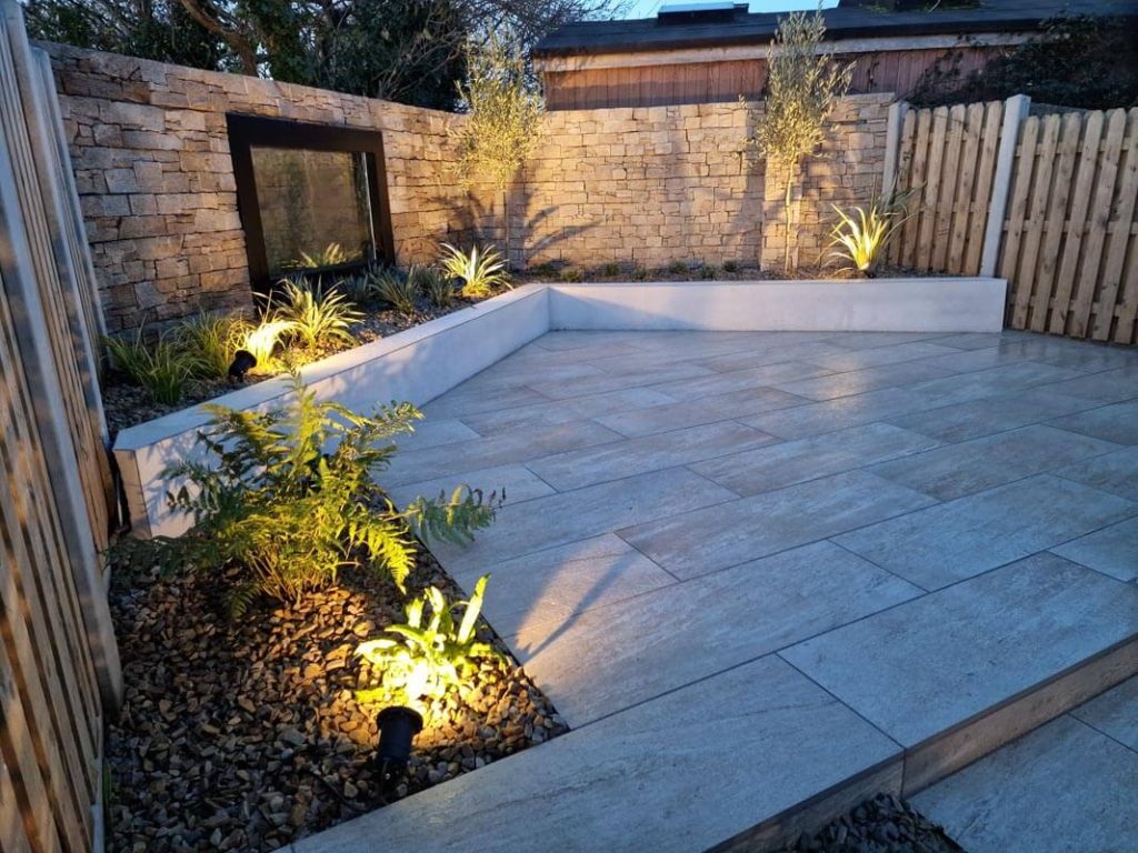 A raised flower bed surrounding a Patio